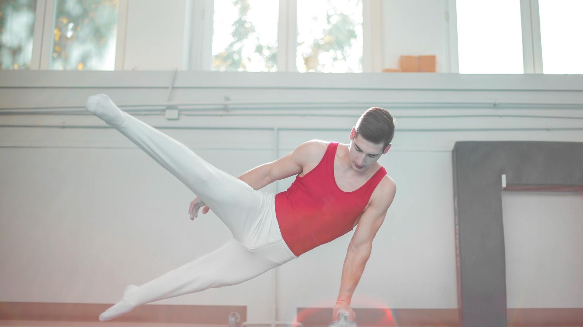 Athletic man performing controlled strength movement in a modern gym