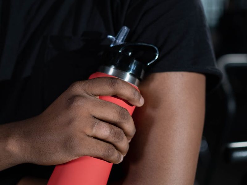Close up of gym equipment and focused male hand during workout